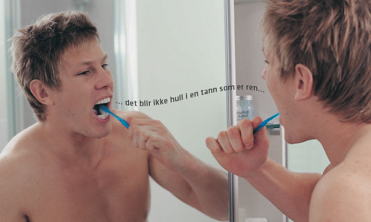Bilde av ung mann i speil som pusser tenner.